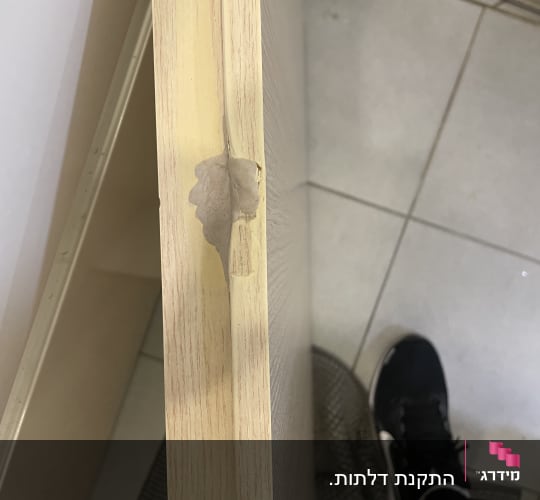 דלת עץ עם פגם בצד העליון